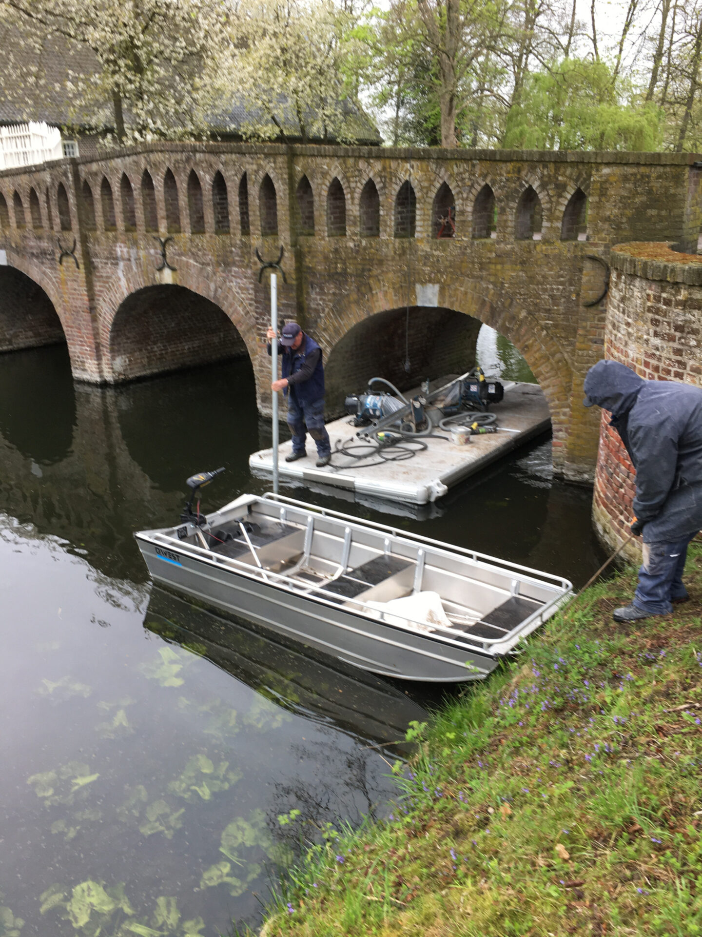 Onderhoud vanaf pontons aan waterburcht van het Kasteel in Well