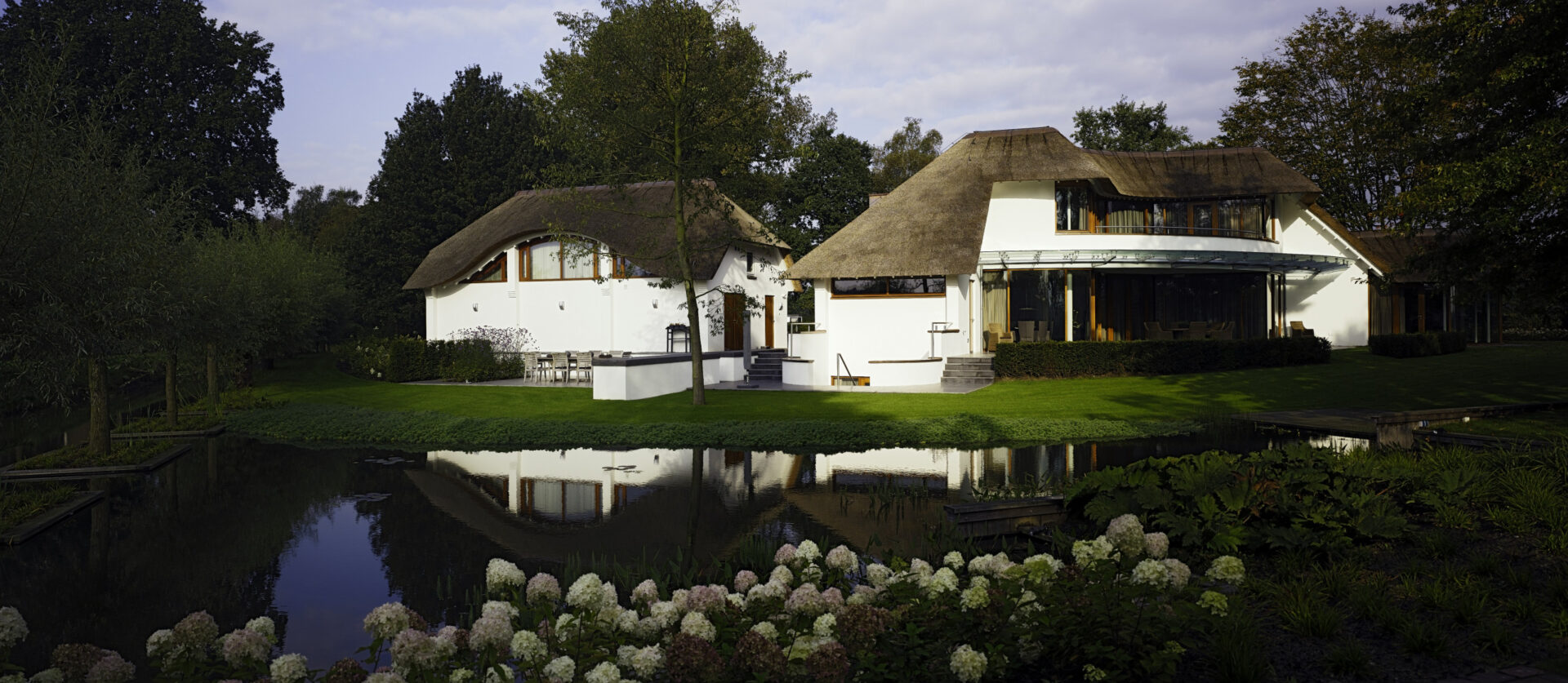 Achteraanzicht van Landhuis Lage Wijst met uitzicht vanuit het water in de tuin