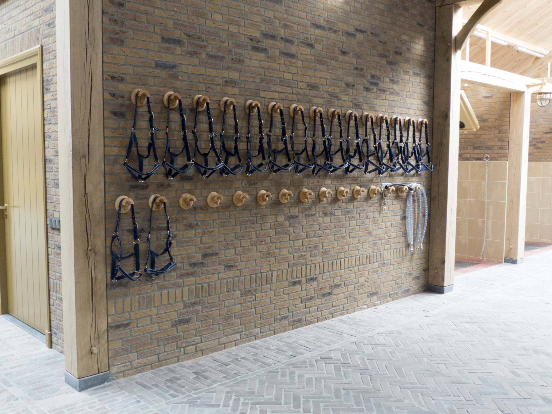 Wand met houten kapstok knoppen waar verschillend hoofdstellen aan hangen