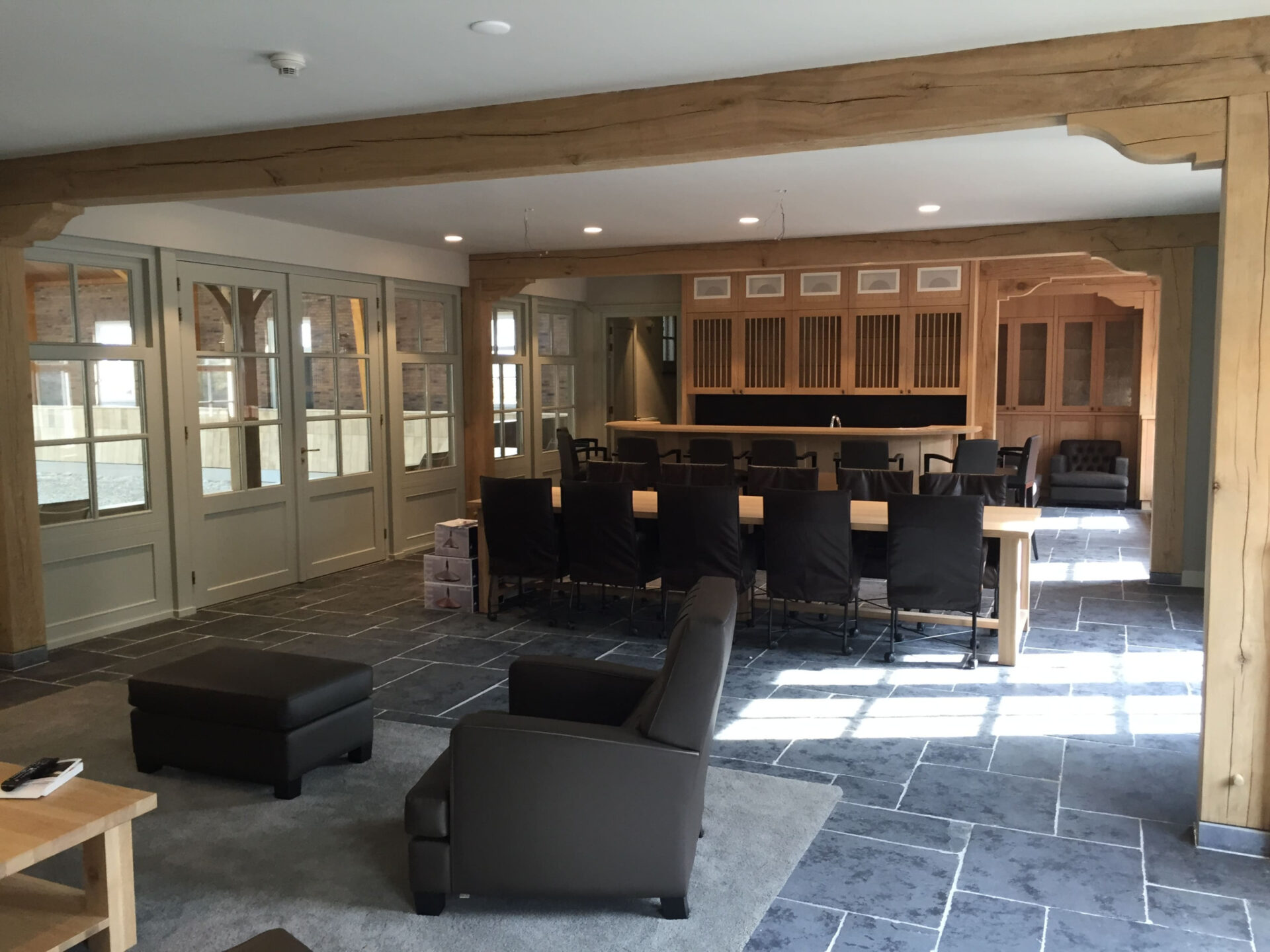 Ruimte met diverse zitplekken. Een tafel met 10 stoelen en een lounge hoek