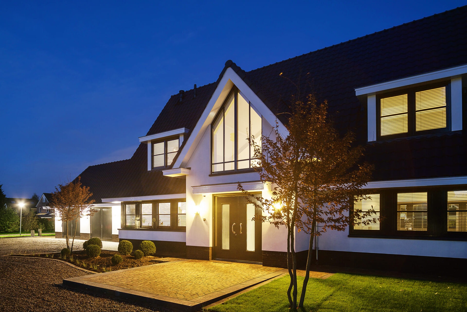 Voorzijde van Villa BB met de nadruk op de entree. De foto is donker waardoor je de verlichting goed ziet.