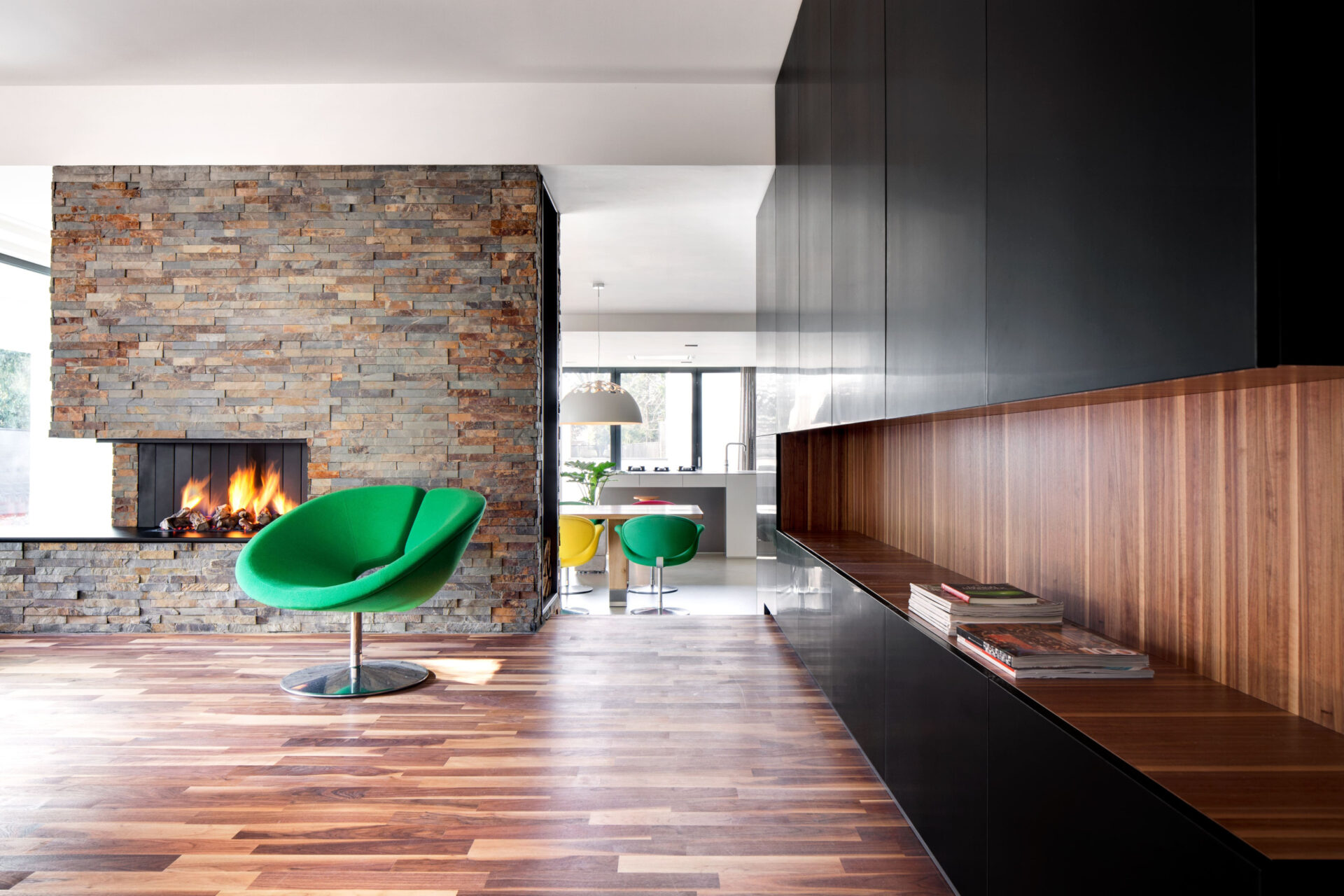 Woonkamer met openhaard en een houten vloer en wandbekleding