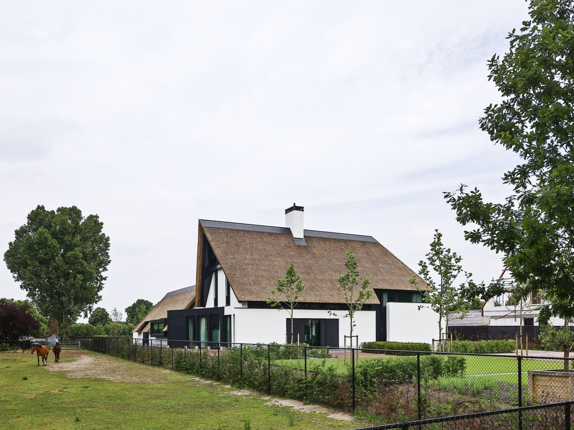 Aanzicht van Villa CH vanaf de weg gezien met een wei naast het huis