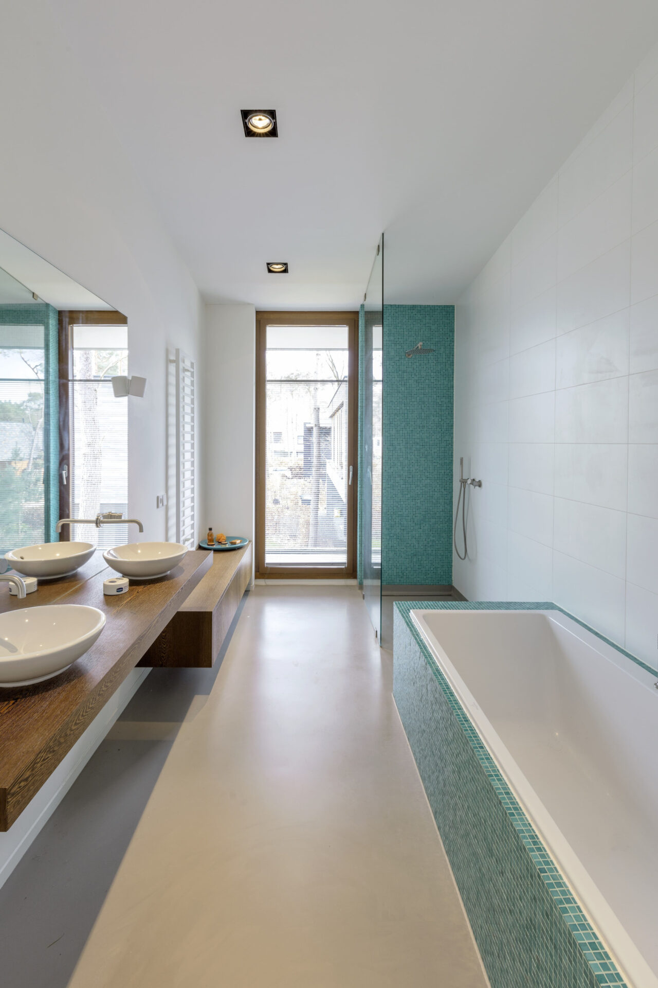 Badkamer aan de binnenzijde van Villa Kerckebosch met blauwe mozaïek tegels. De badkamer heeft een bad en een douche