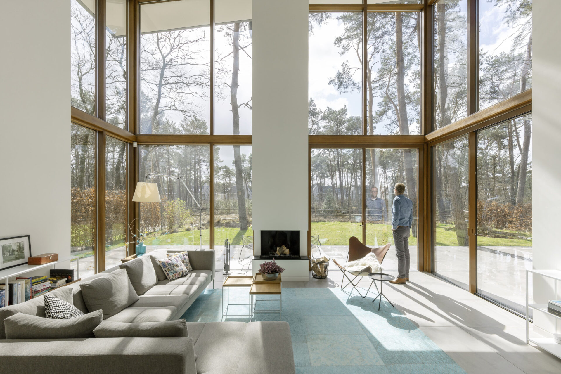 Binnenzijde van Villa Kerckebosch vanuit de woonkamer gezien. Er staat een man die naar de tuin kijkt