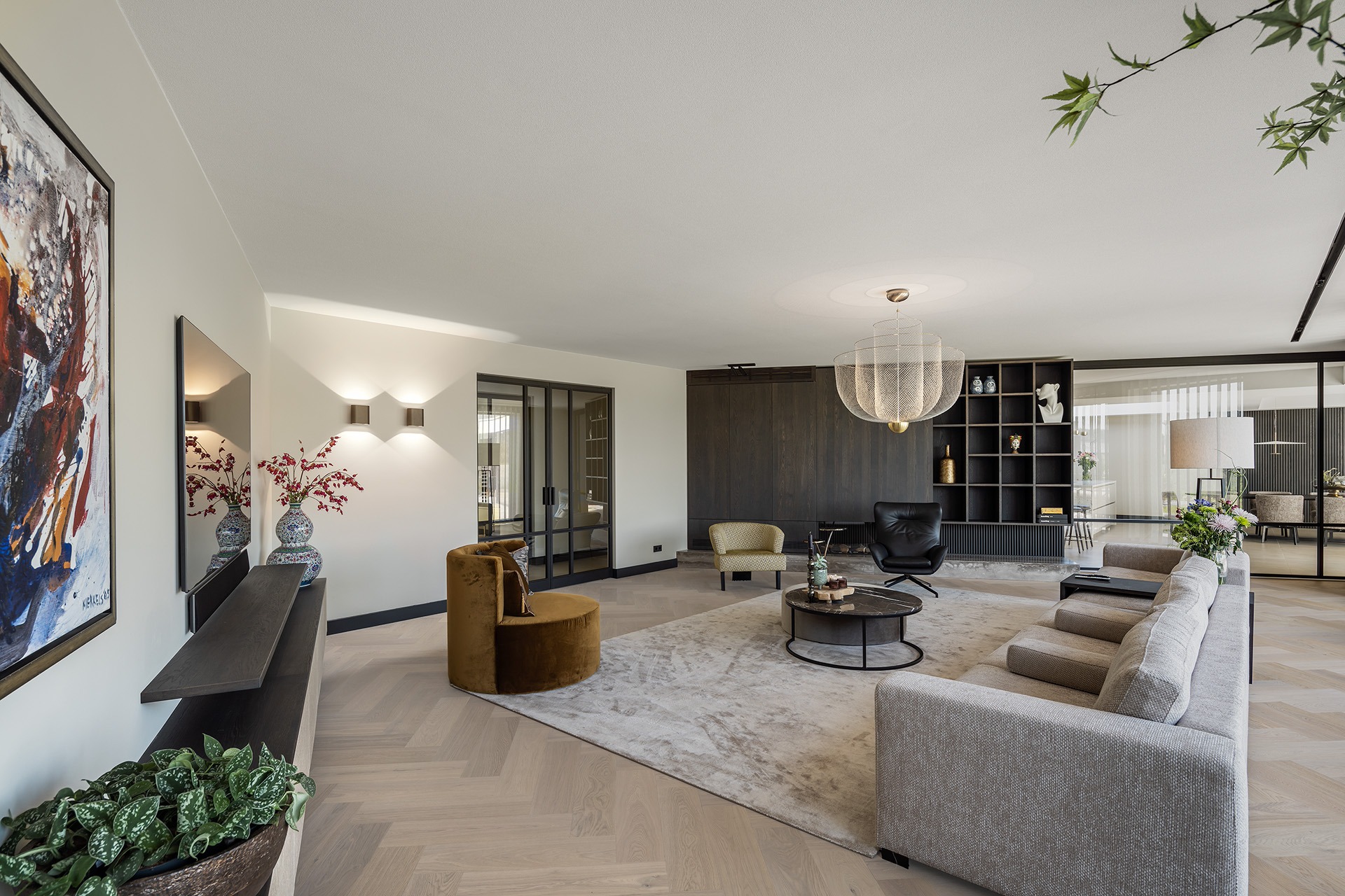 Moderne woonkamer van Villa MB met daarin een bank, diverse stoelen en een tv.