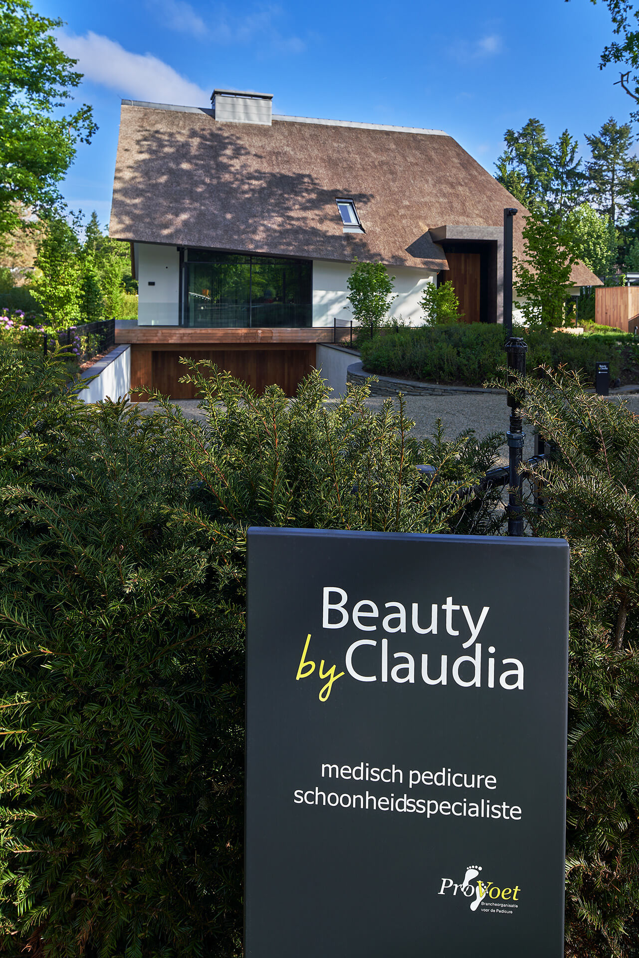 Voorzijde van villa ms met een reclamezuil van Beauty by Claudia, een medisch pedicure en schoonheidsspecialiste