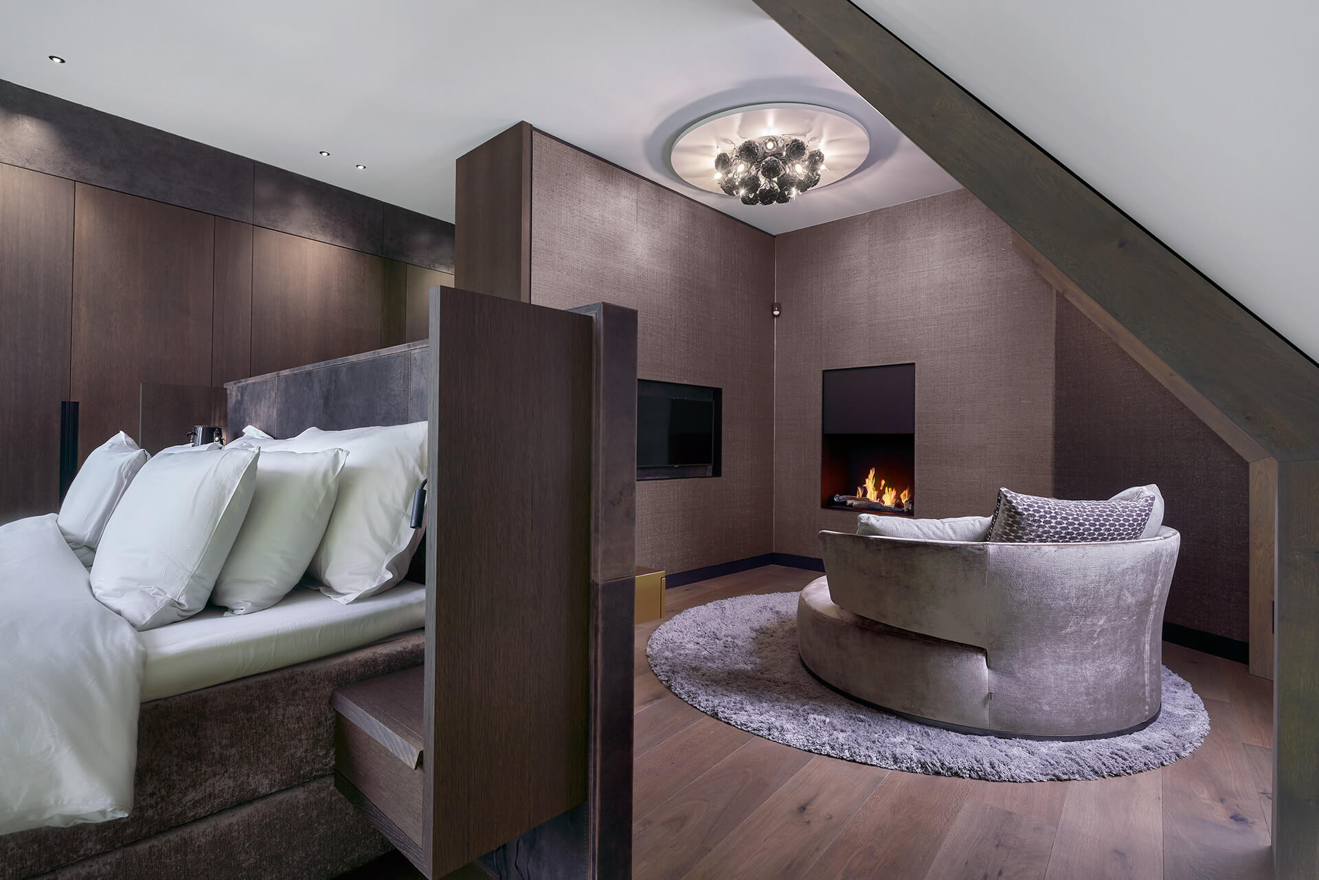 Slaapkamer met een grote fauteuil voor haard
