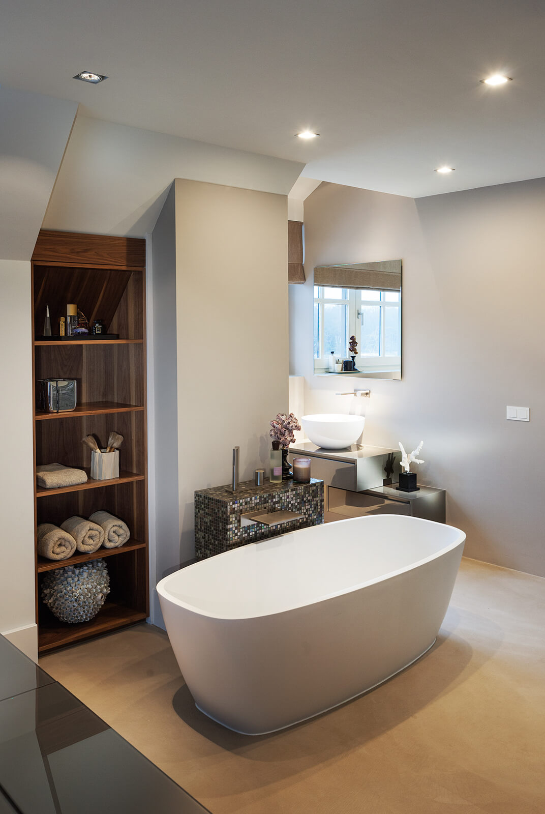 Detailfoto van badkamer in Villa SL. Op de voorgrond een bad en op de achtergrond een wastafel met spiegel