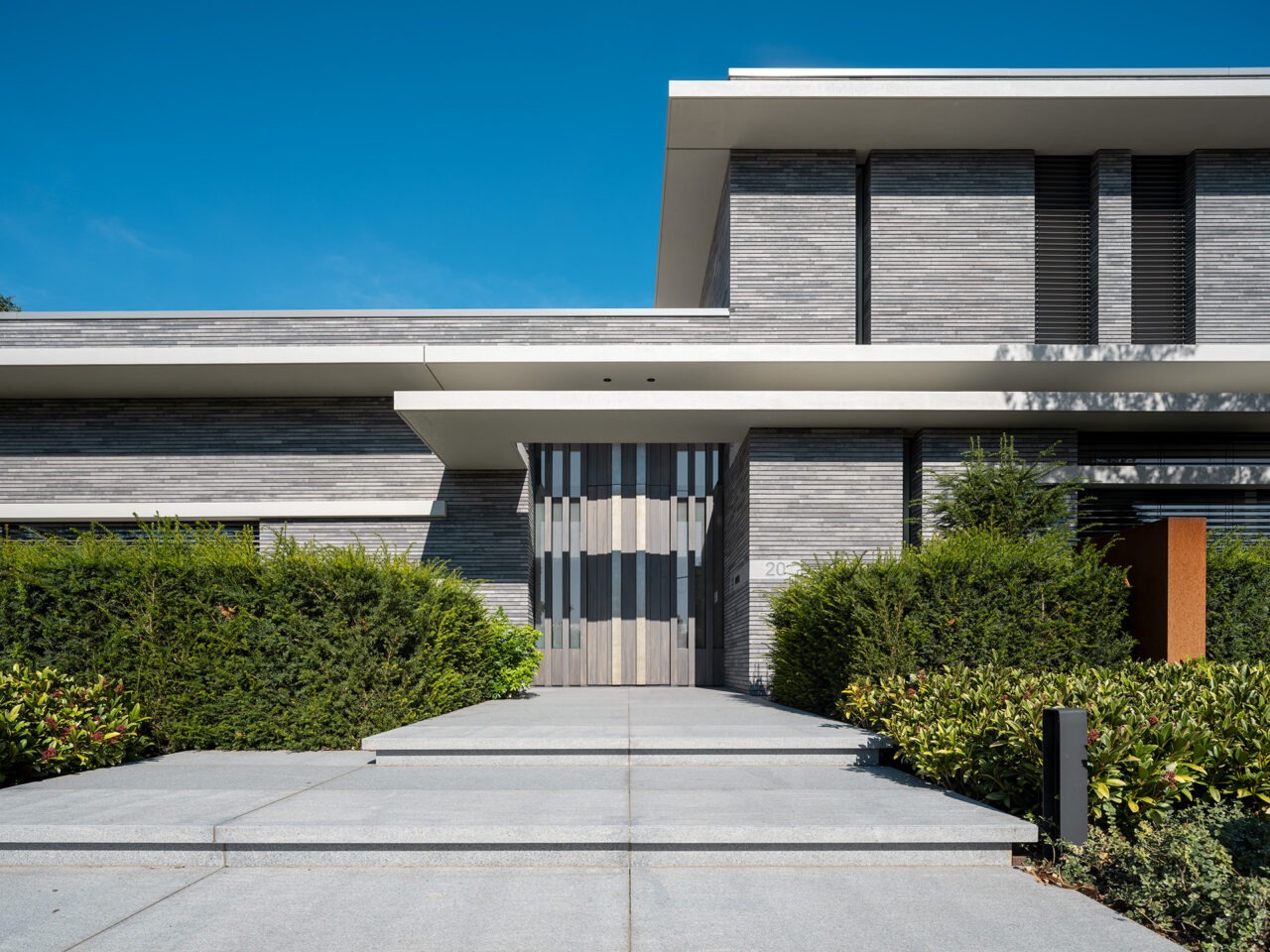 Vooraanzicht van moderne entree aan de buitenzijde van Villa WU