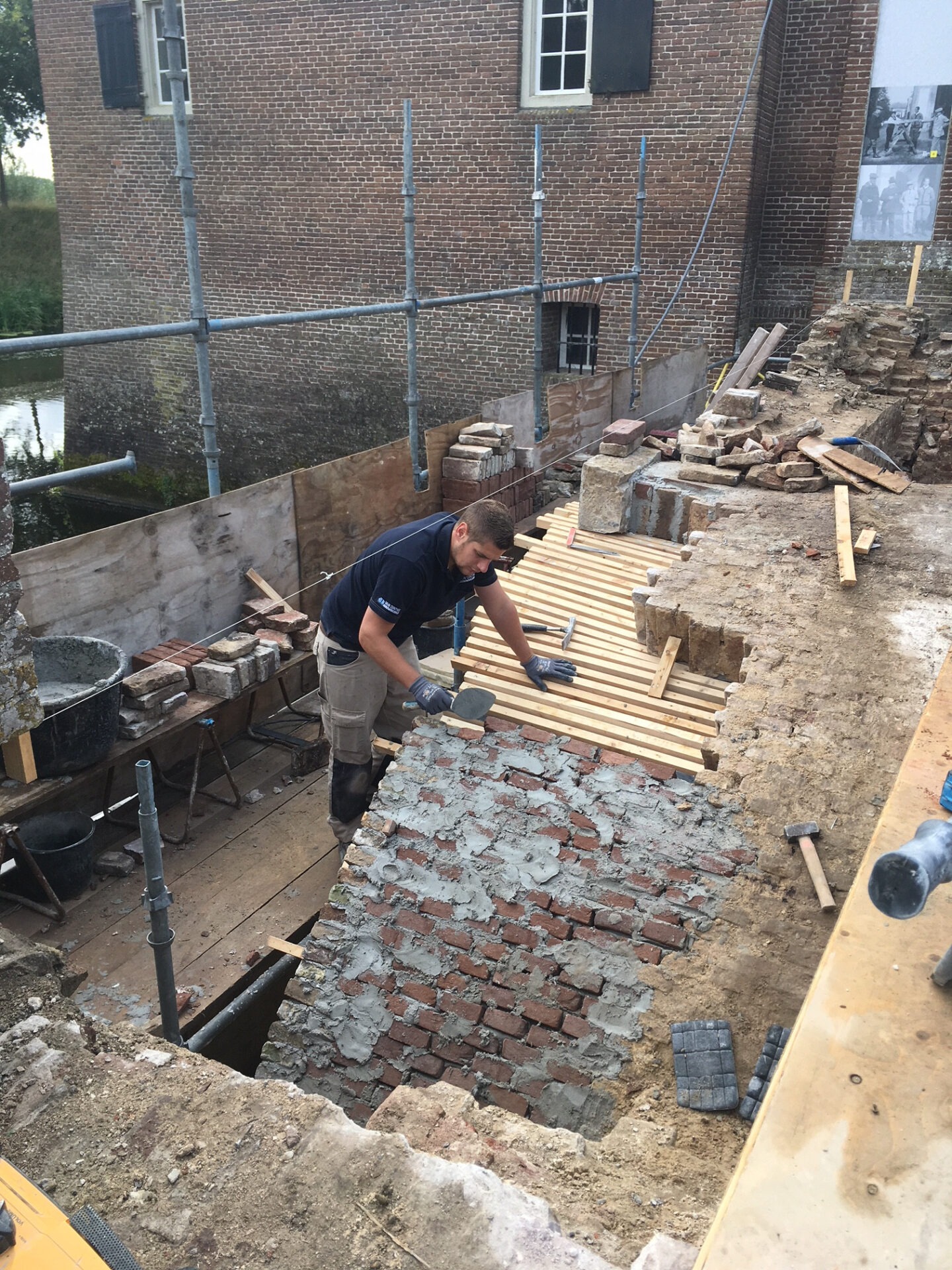 Metselaar van Van Dinther tijdens restauratie van metselwerken op de brug van Kasteel Amerongen