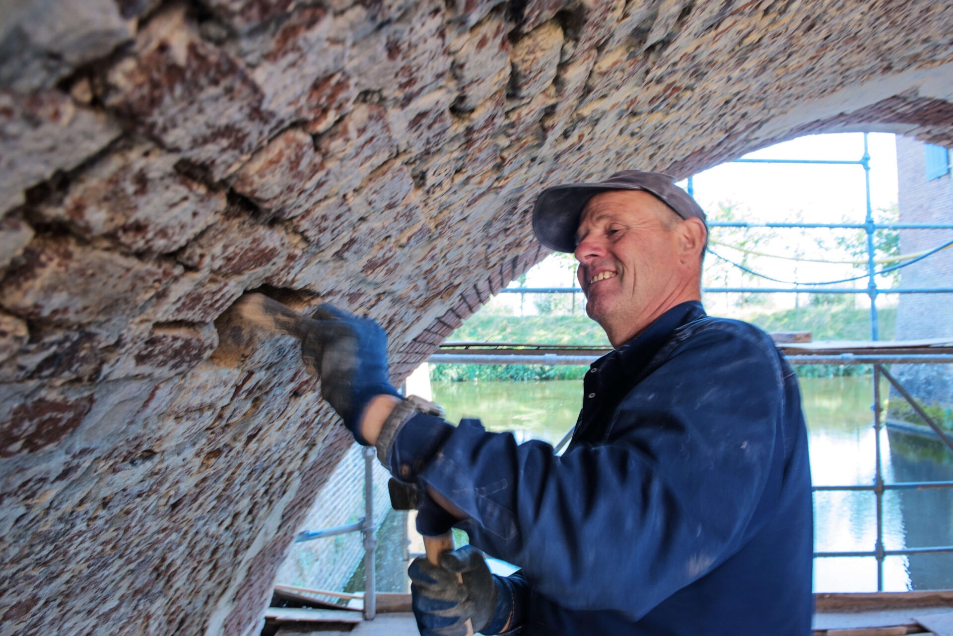 Metselaar van van Dinther aan het werk in een van de bogen van de brug van Kasteel Amerongen