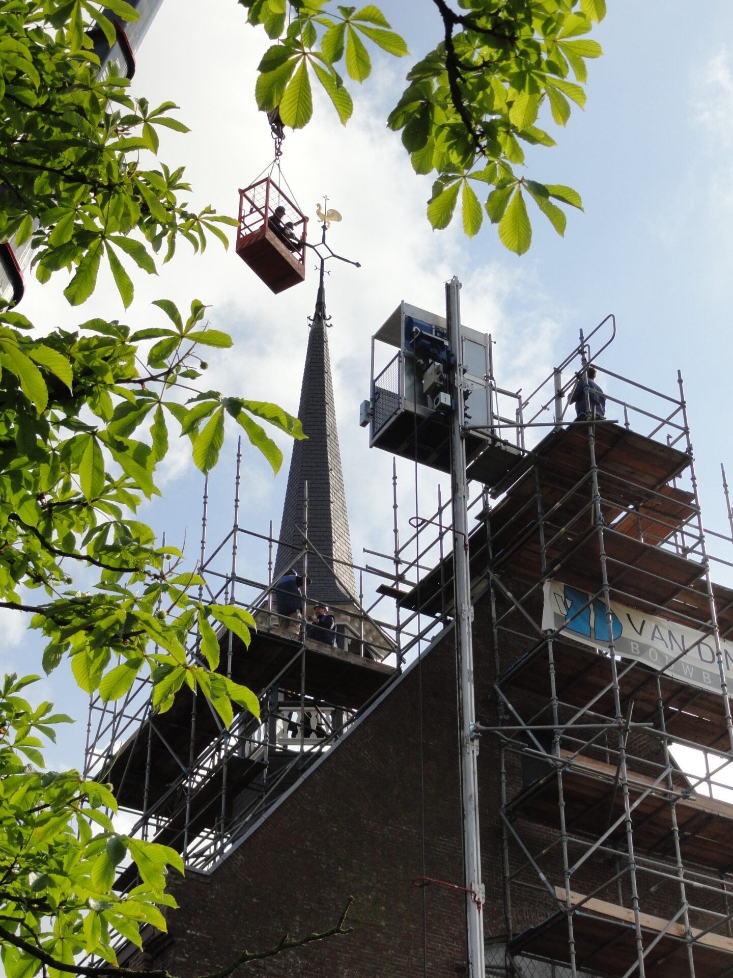 Herstelwerkzaamheden door medewerkers van Van Dinther in een hoogwerker en op een steiger