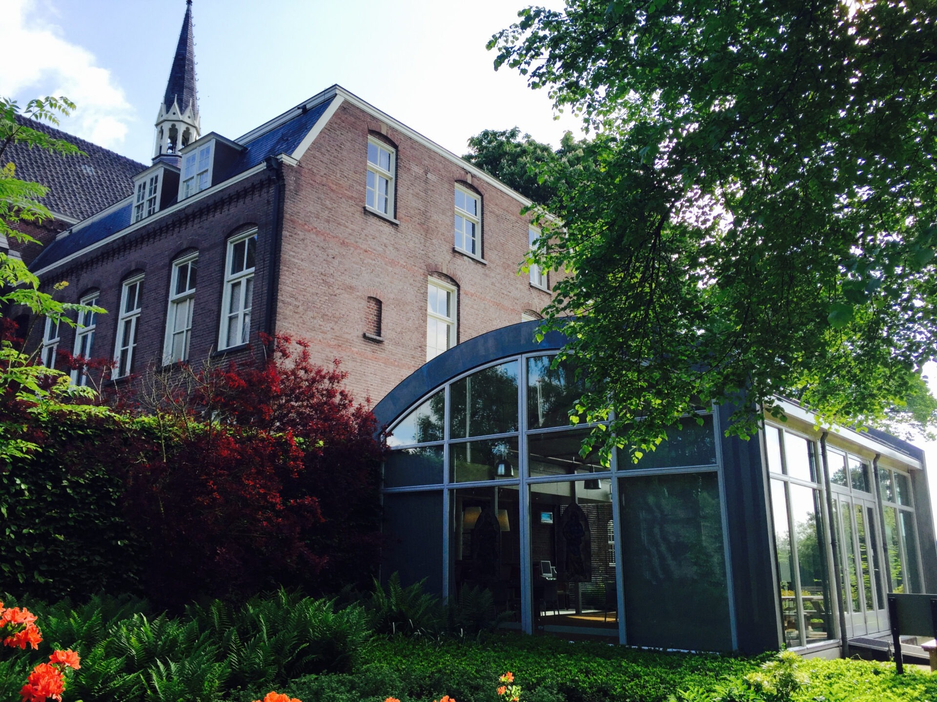 Zijaanzicht glazen bijgebouw bij Klooster Soeterbeeck