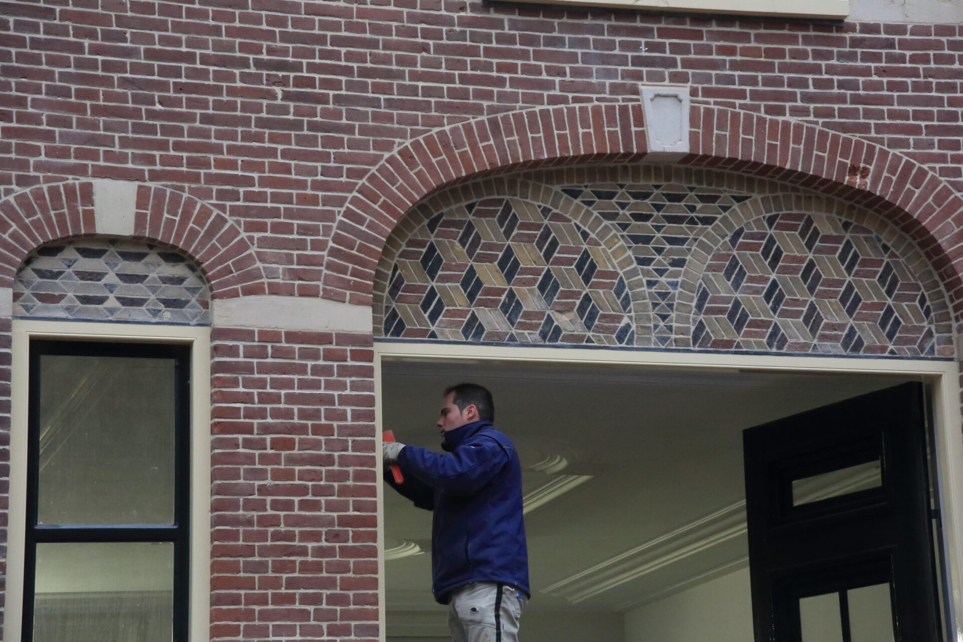 Medewerker van Van Dinther tijdens restauratiewerkzaamheden aan de kozijnen van het Koetshuis in Vught
