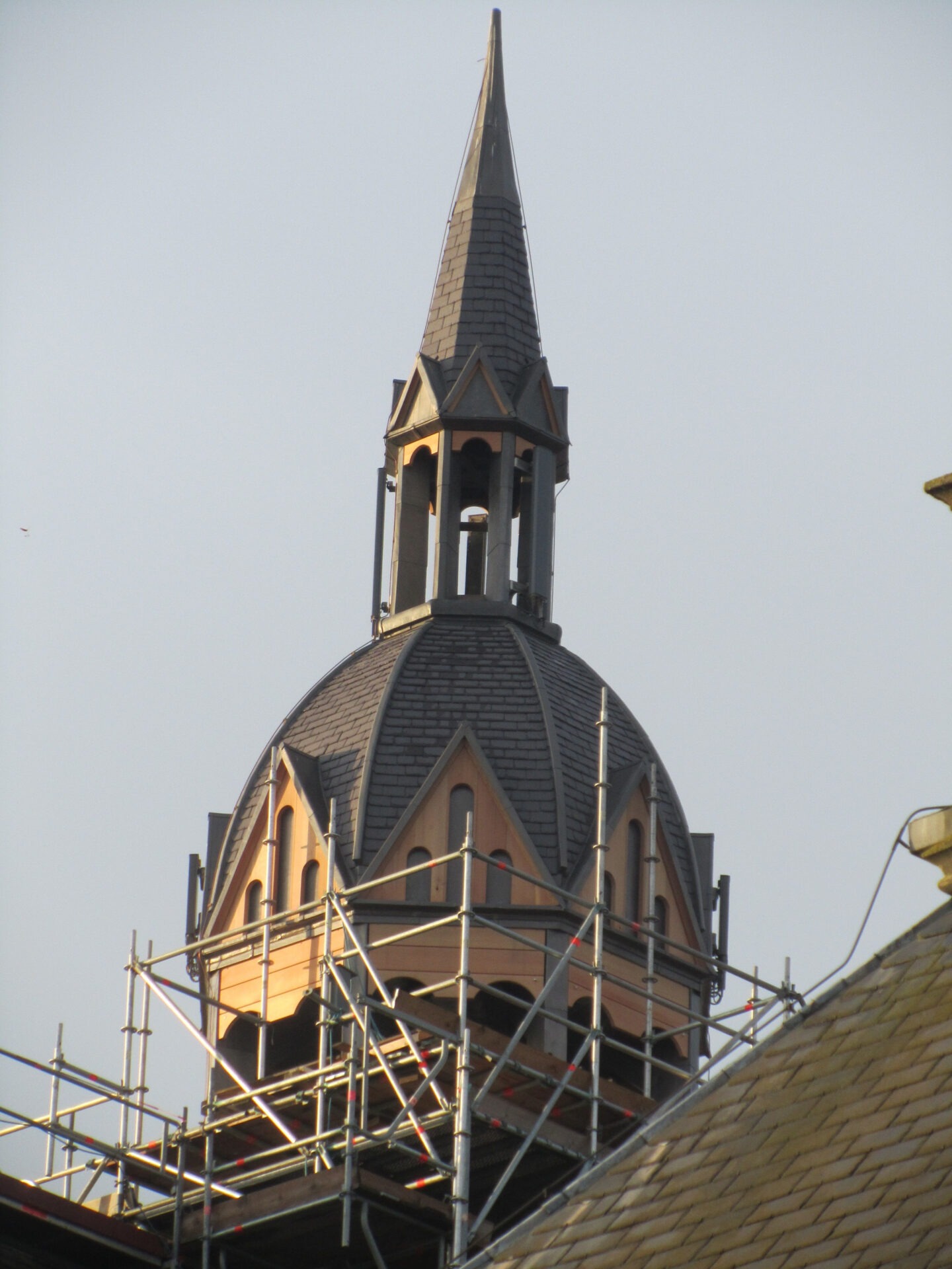 Detailfoto van de toren van de R.K.H. Alphonsuskerk in de steigers