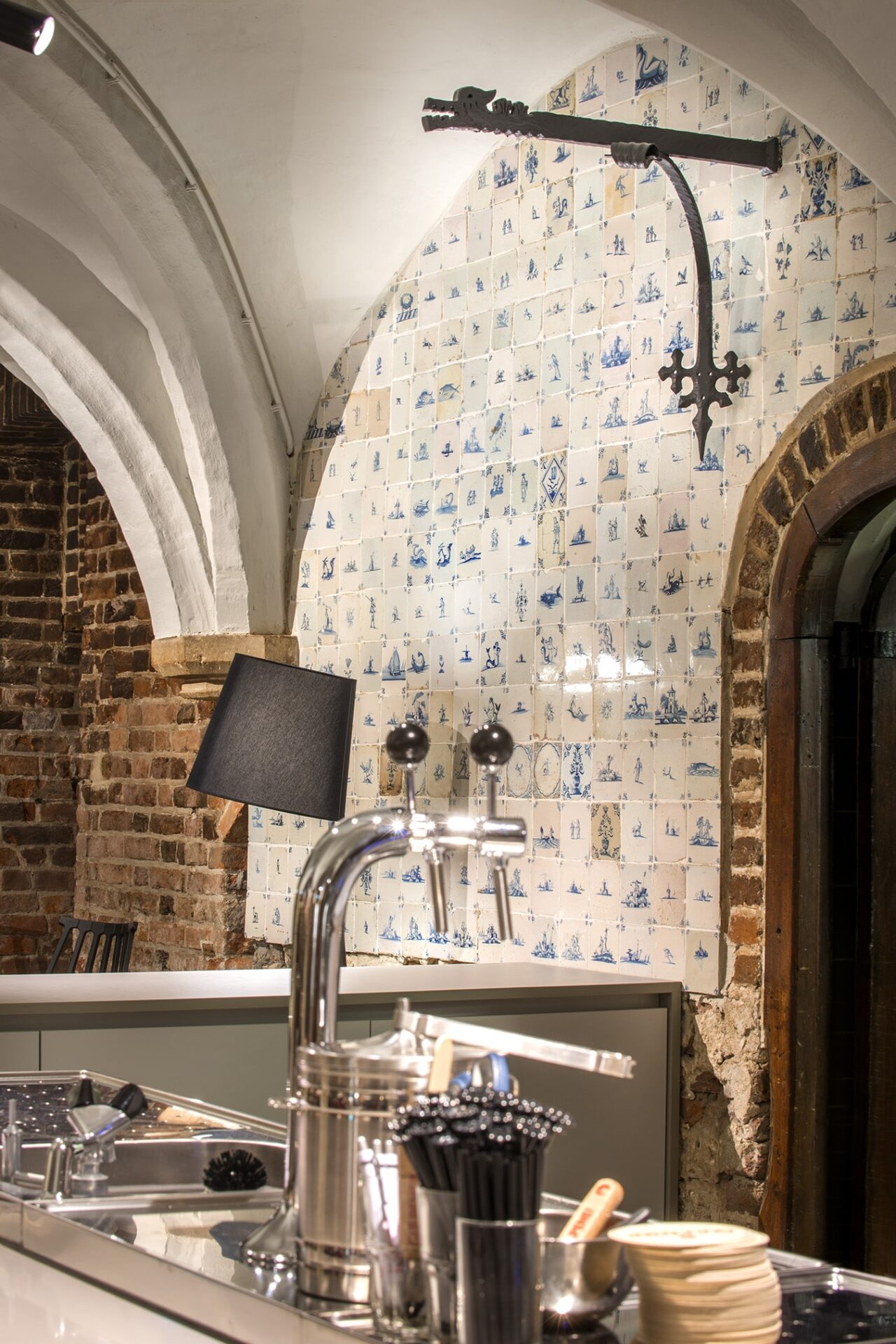Close up van een van de gewelven van de Raadskelder in 's-Hertogenbosch met daaronder Delfst blauwe tegeltjes