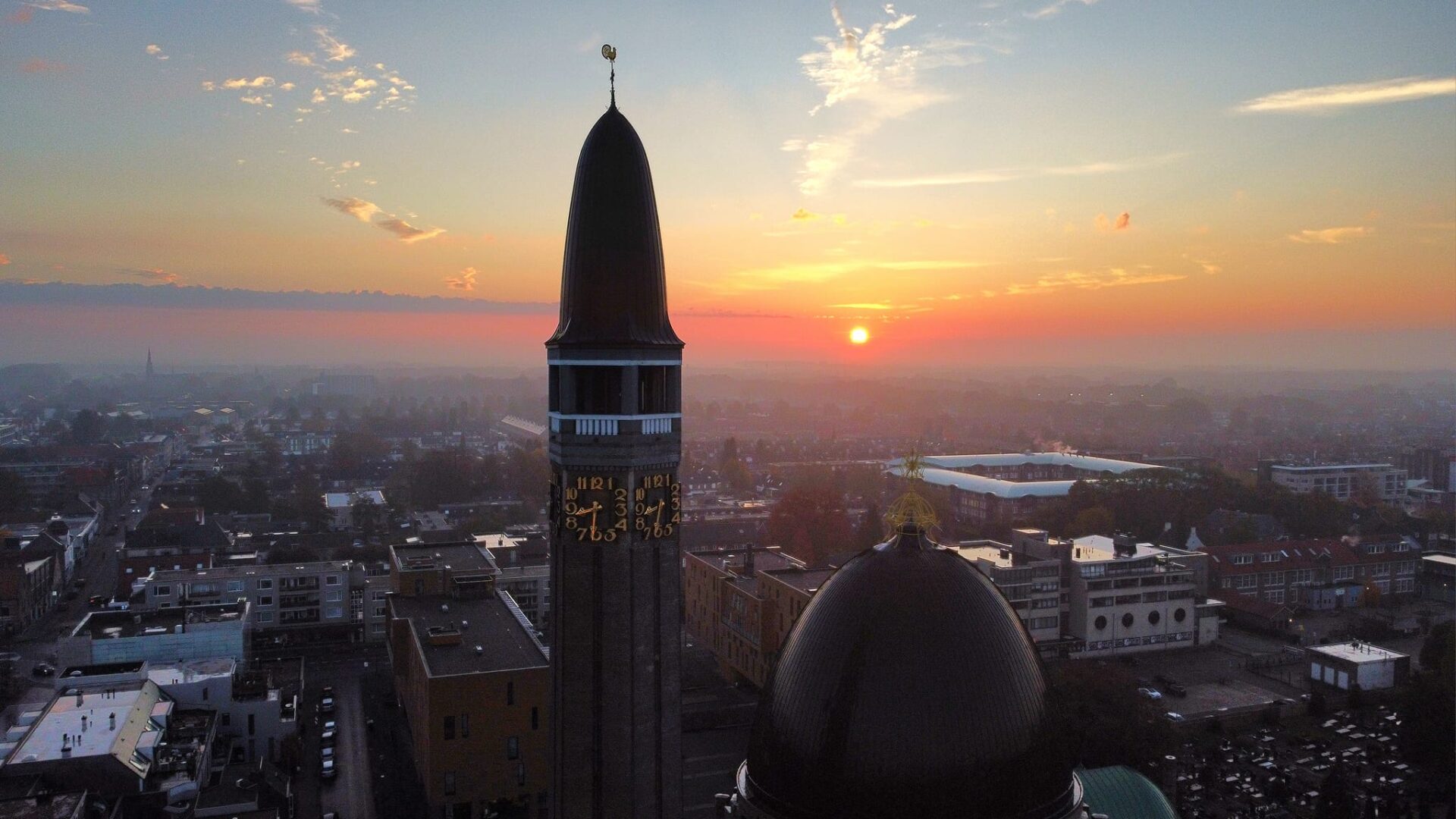 Toren van de Sint Janskerk met klok in bij zonsopgang