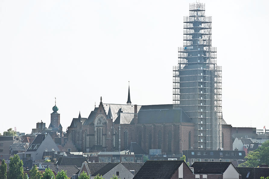 Aanzicht van de Stevenskerk tijdens de restauratiewerkzaamheden. De toren staat in de steigers