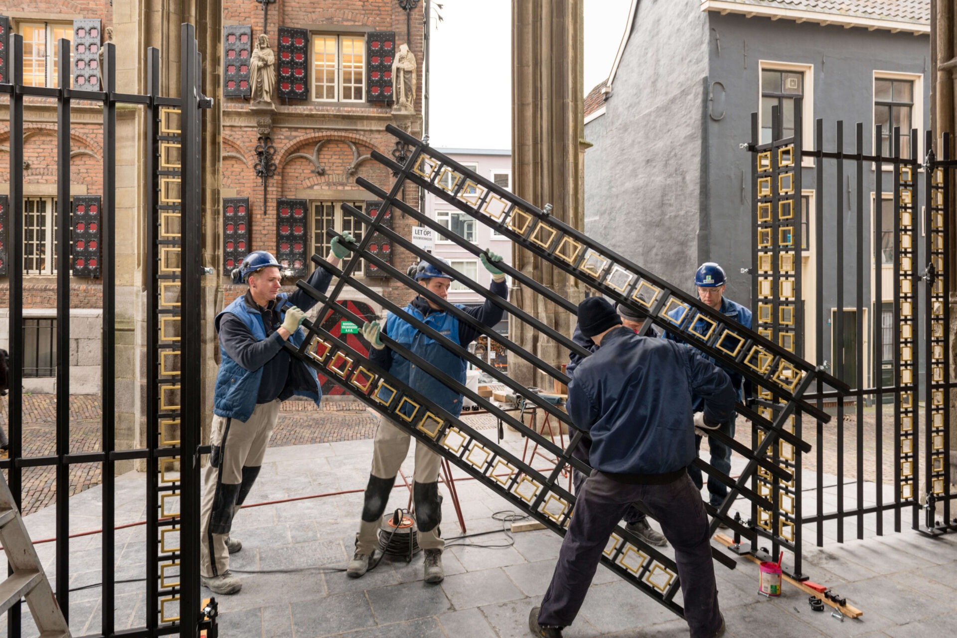 Medewerkers van Van Dinther plaatsen de poort bij de ingang van de Stevenskerk