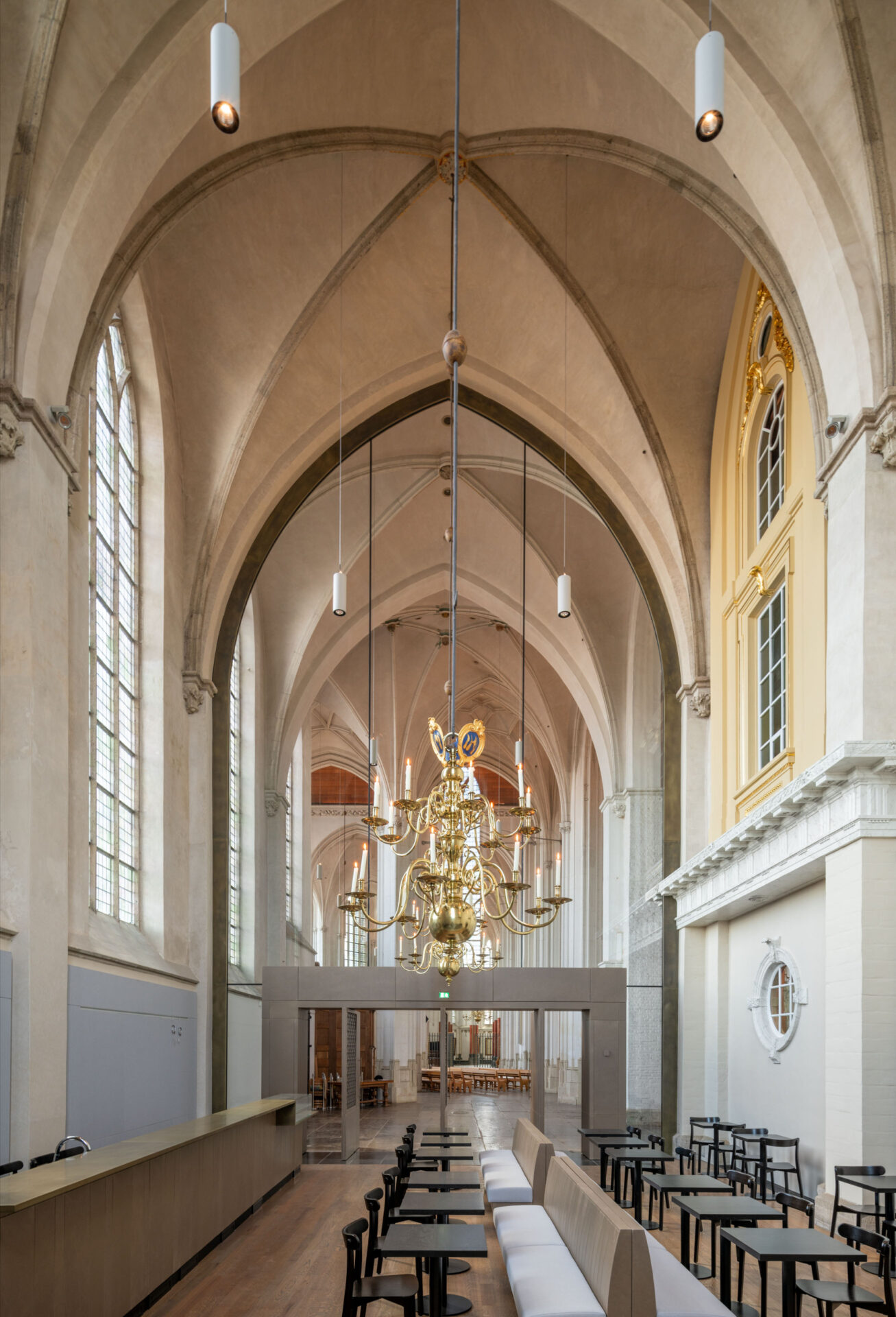 Gouden kroonluchter in de binnenzijde van de Stevenskerk met ruimte om te zitten