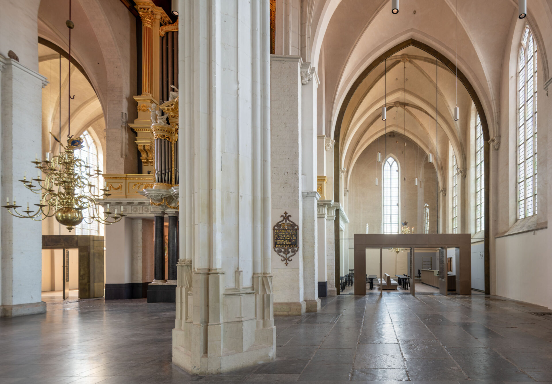 Binnenzijde Stevenskerk met gouden kroonluchter, een pilaar en het orgel
