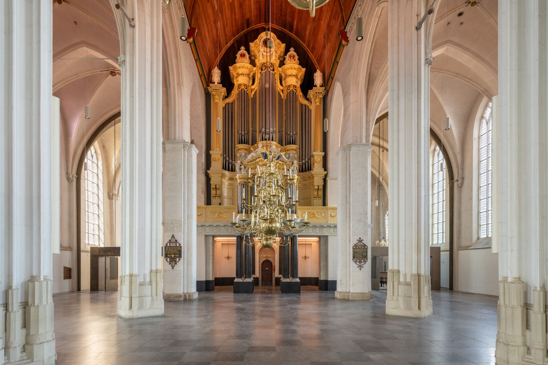 Binnenzijde van de Stevenskerk. Op de voorgrond een gouden kroonluchter en op de achtergrond het orgel