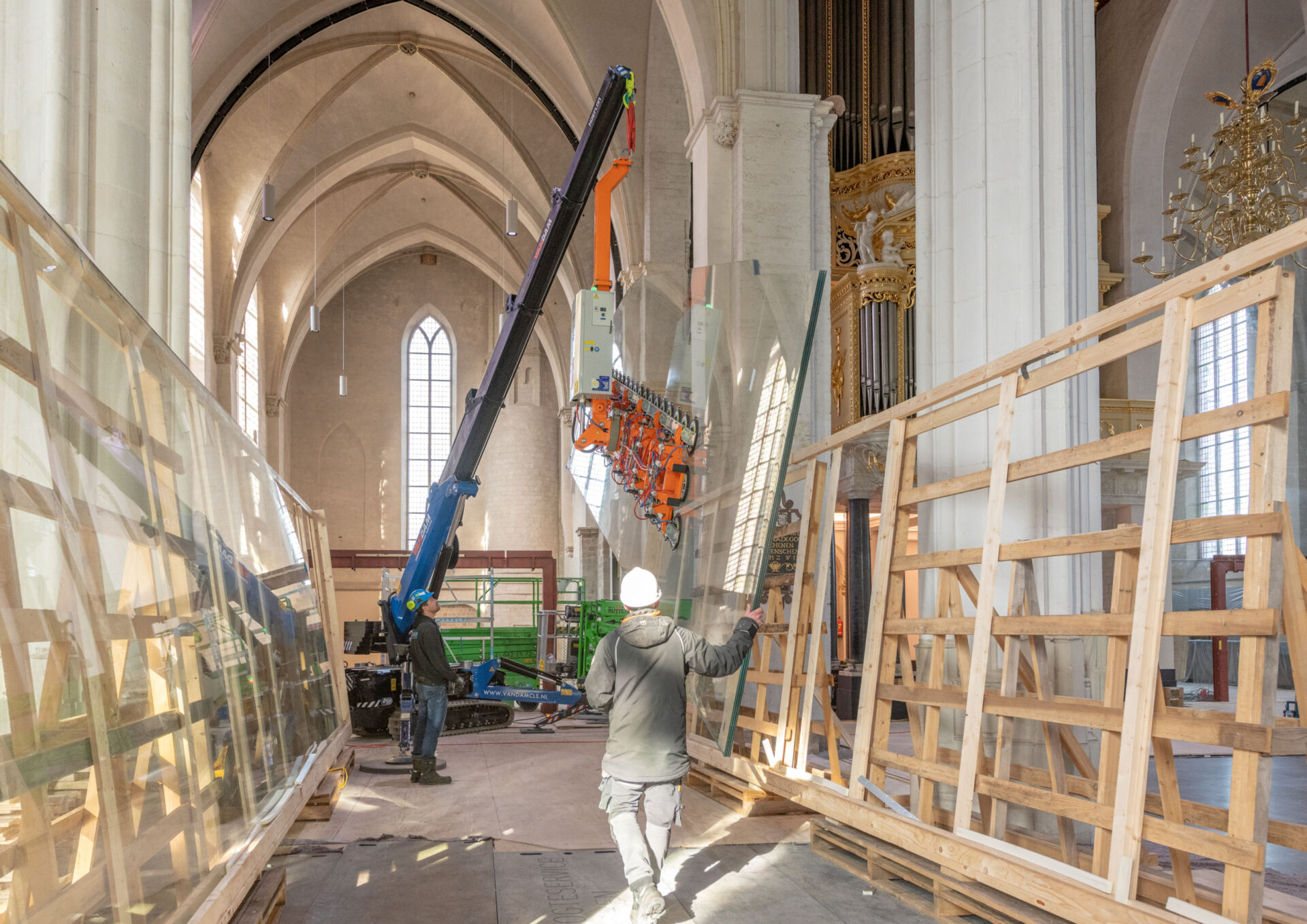 Het plaatsen van de glazen scheidingswanden door middel van een hoogwerker in de Stevenskerk