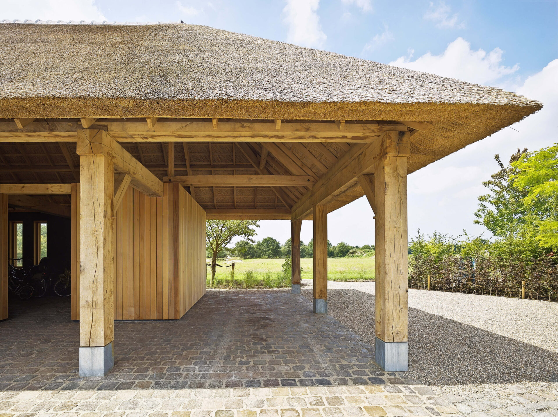 Zijaanzicht van een gebouw met een rieten kap en een houten constructie